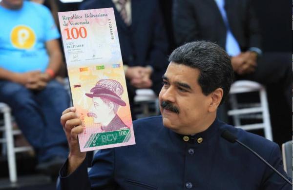 委内瑞拉总统马杜罗22日展示将发行的百元面值的"强势玻利瓦尔"样币.