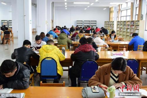 资料图:2017年11月22日,山东青岛,考研生在图书馆内埋身书海认真复习。小老茂 摄 图片来源:视觉中国
